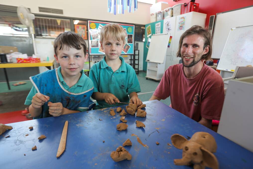 Creative: Warrnambool West Primary School students Xavier Hales, 8, and Bailey Hales, 6, gets some help with their clay sculptures from local artist Xavier Lane at the new after-school program. Picture: Rob Gunstone
