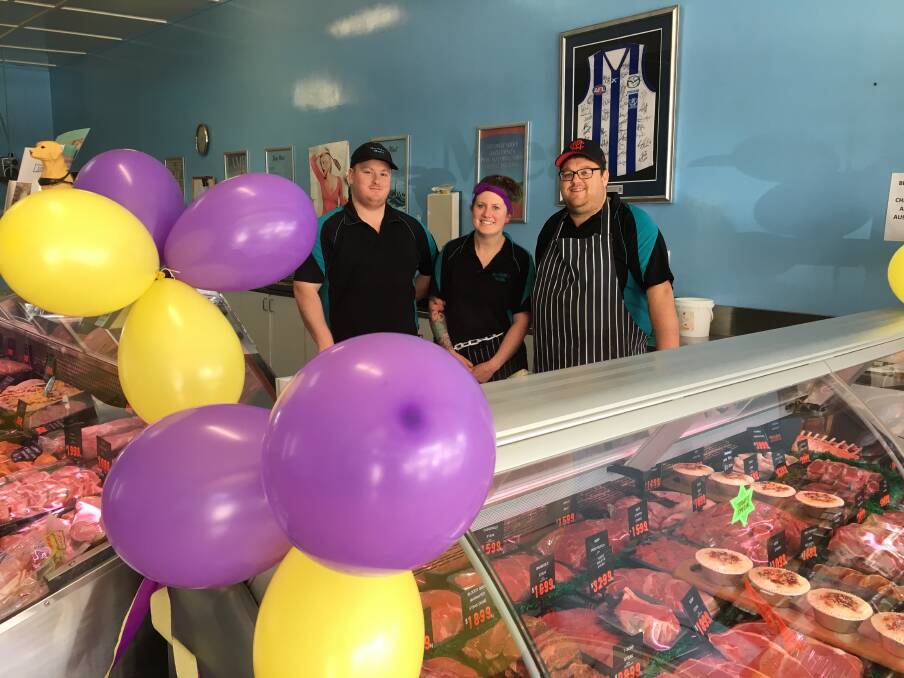 Go Port: Sheehan's Meats employees Zac Arnott, Tam Squire and Tony Jackson in the shop which is decorated ahead of this weekend's Hampden League grand final.
