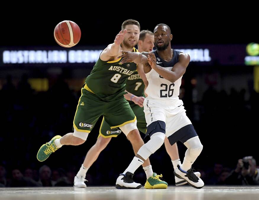 TOUGH TUSSLE: Australia's Matthew Dellavedova and Team USA's Kemba Walker battle for possession at Marvel Stadium on Thursday night. Dellavedova had 10 points and six assists from 26 minutes' court time. Picture: AAP 