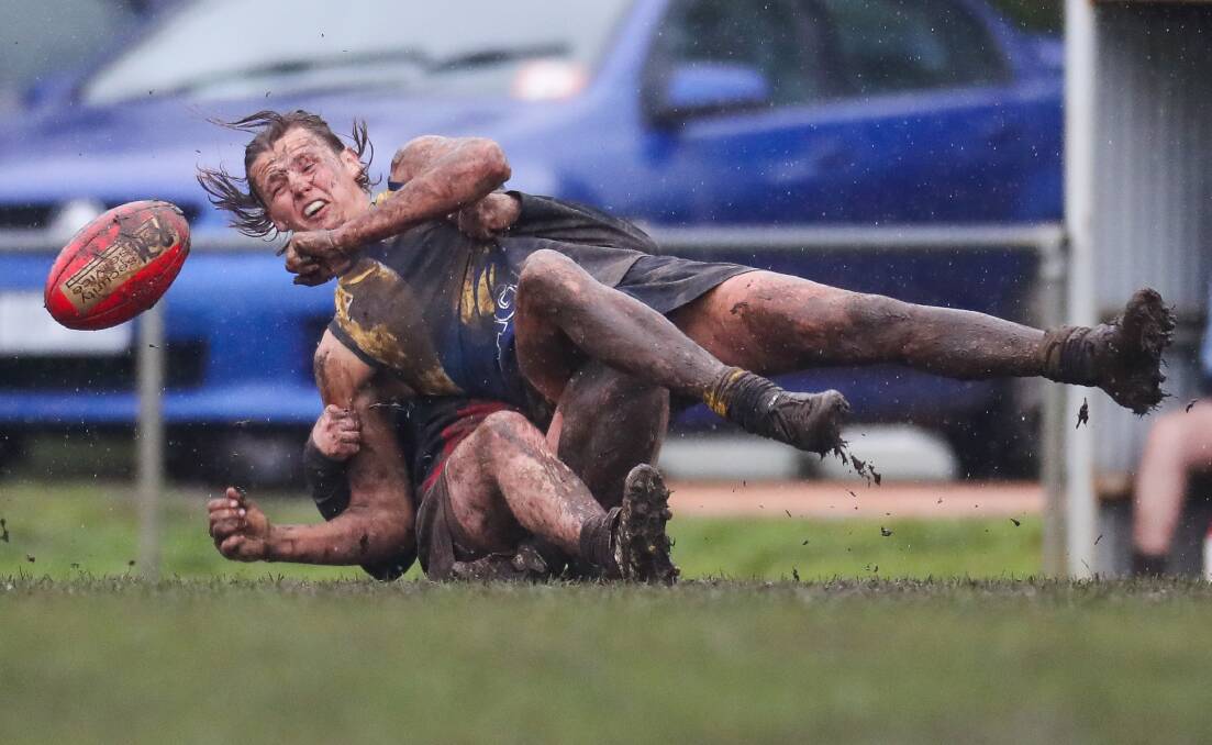WET 'N' WILD WINTER: North Warrnambool Eagles' Sam McLachlan is tackled with the ball at a muddy Bushfield Recreation Reserve. Picture: Morgan Hancock 