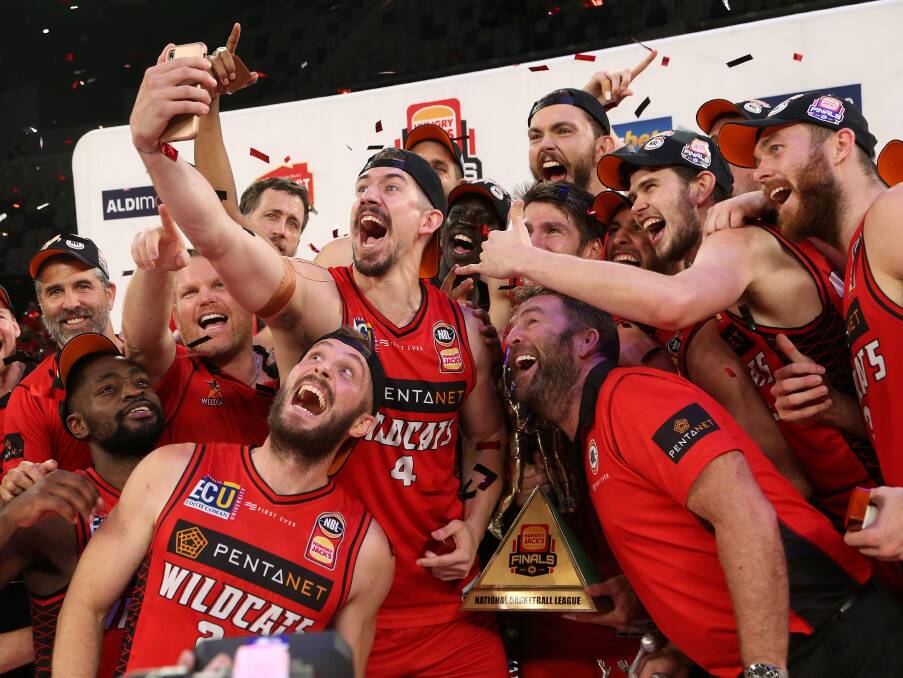 SAY CHEESE: Retiring Wildcat Greg Hire takes a championship selfie with his teammates and coach Trevor Gleeson. Picture: AAP 