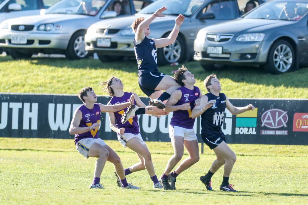 LEAP OF FAITH: Warrnambool teenager Harry Ryan, who kicked the sealer against Port Fairy, flies high in a marking attempt. Picture: Morgan Hancock
