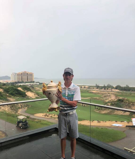 ON TOP OF THE WORLD: Warrnambool's Caleb Perry with the Vietnam Junior Open trophy.