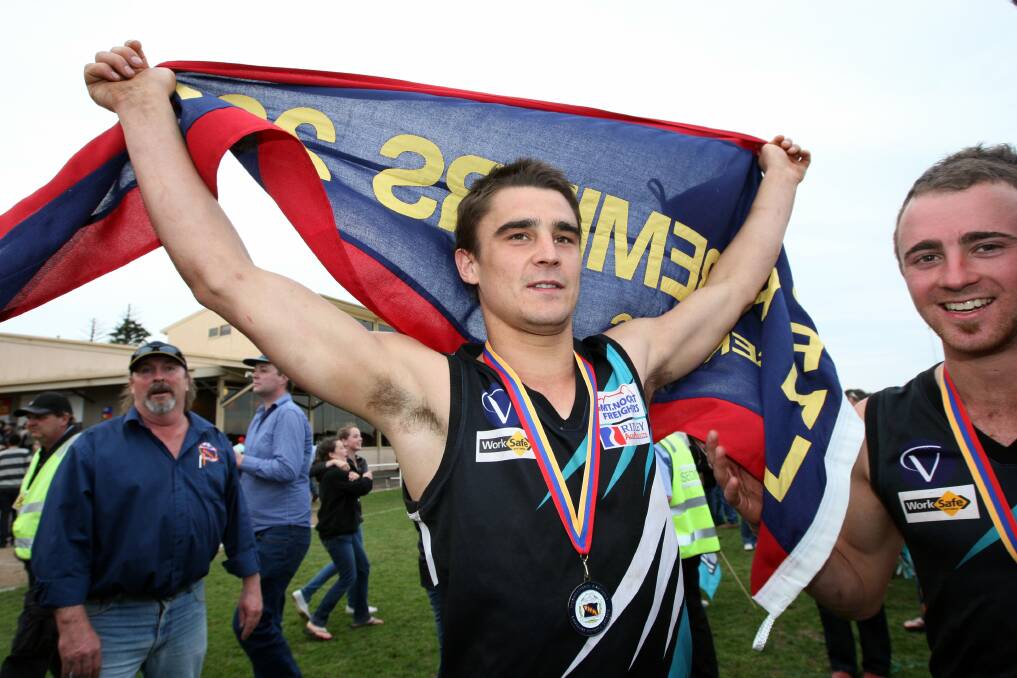 Great memories: Brad Johnson lifts a premiership flag after winning the 2011 WDFNL grand final with Kolora-Noorat. He'll play his 150th game for the Power this Saturday.
