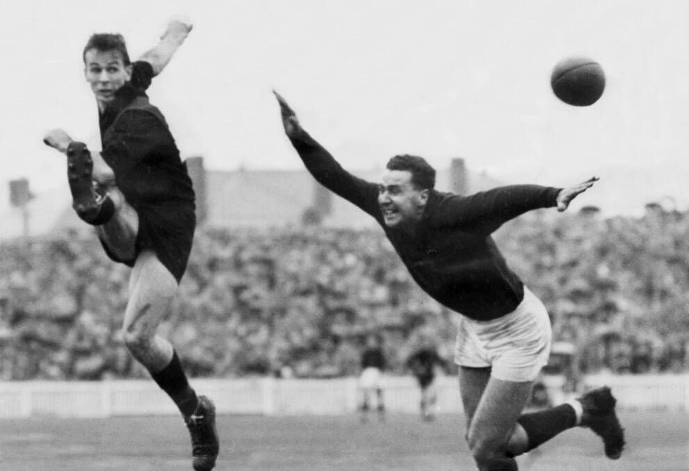 STAR: Essendon's John Coleman kicking for goal under pressure from Fitzroy defender Alan Gale during a game in 1953. Coleman was born in Port Fairy.  