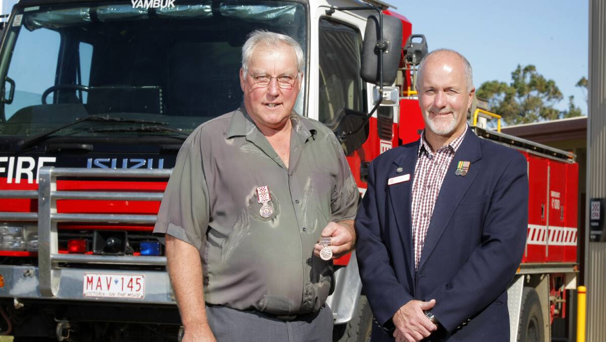 Back: Michael Tudball, right, in his former role as a CFA board member, presenting a  service medal to Yambuk CFA's Geoff Youl in 2013. 