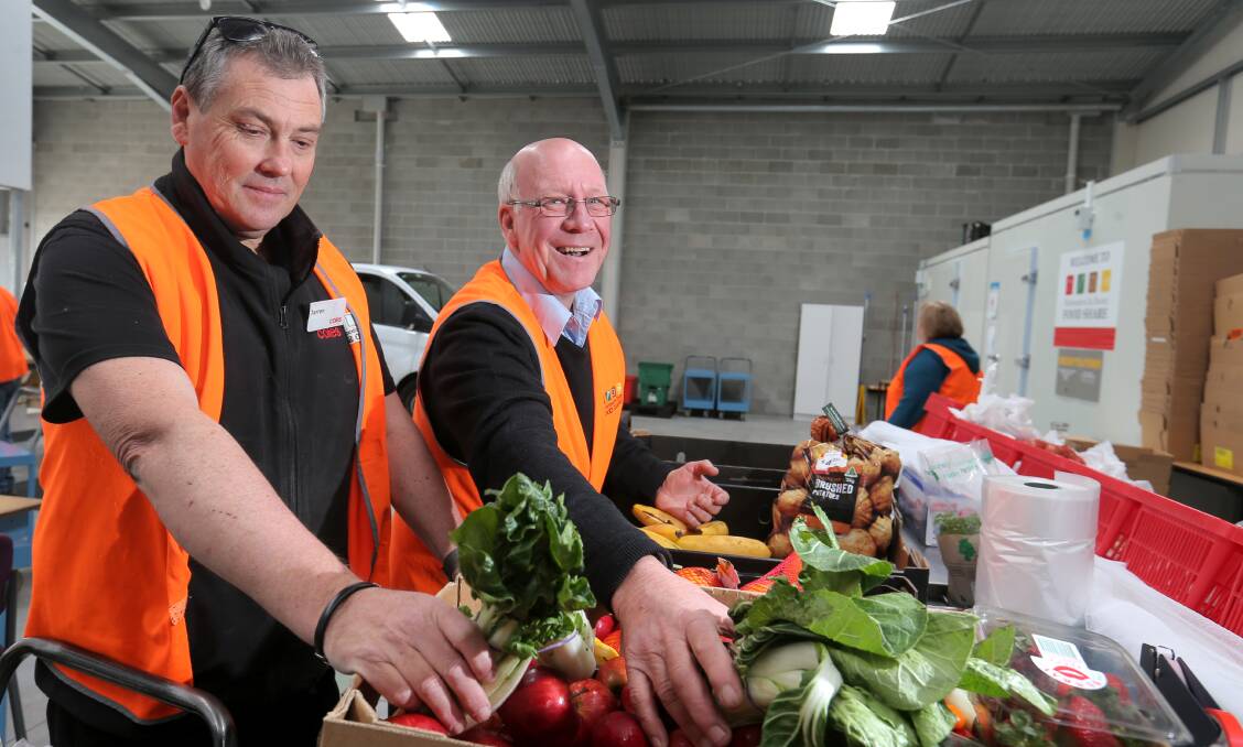 Growing need: Warrnambool FoodShare's Dedy Friebe, right, and Coles worker Darren Turner pack vegetables for people in need during FoodShare's earlier years. 