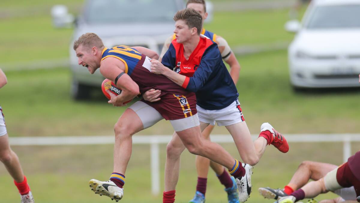 GAME TIME: Braden Hotker of the South Rovers tries to evade a tackle from Timboon's Bayley Thompson. Picture: Morgan Hancock