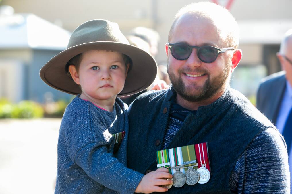 All in: James Mepham, of Warrnambool, carries his daughter Elliott, 3, during an Anzac Day march.