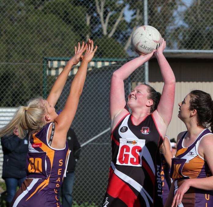 SHOOTING CLEAR: Port Fairy goal defence Carly Watson stretches as Koroit goal shooter Nell Mitchell holds her shot. Mitchell finished with 43 goals for the game. Pictures: Rob Gunstone