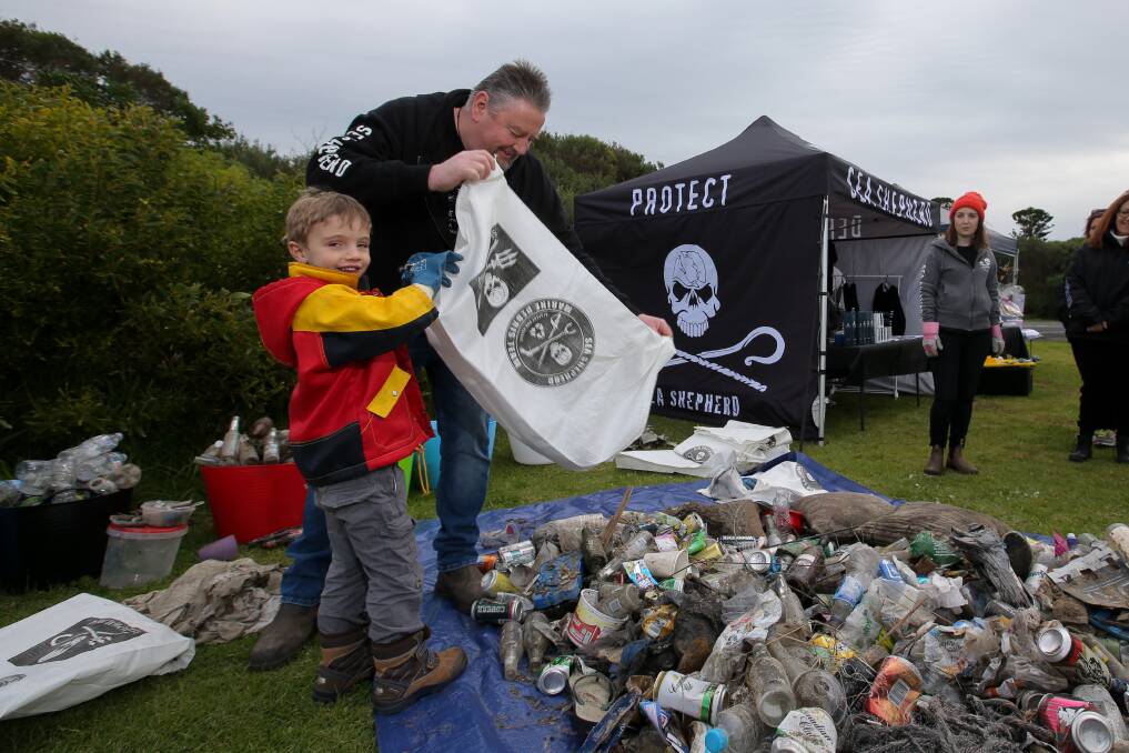 Teamwork: Sea Shepherd on shore volunteer Andrew Holt gets some help from Louis O'Brien, 4 of Warrnambool in emptying a collection bag at the Warrnambool foreshore.