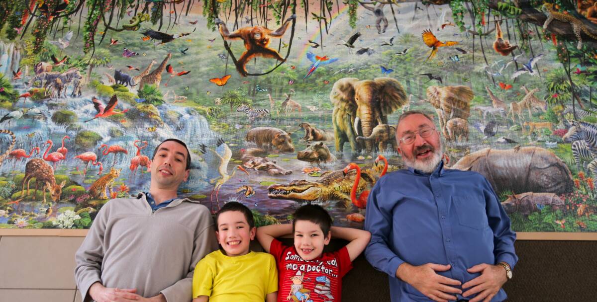 Complete: Ben Philpot, with sons Matthew, 9, and William, 7, and dad John in front of the 33,600-piece jigsaw puzzle. Picture: Rob Gunstone