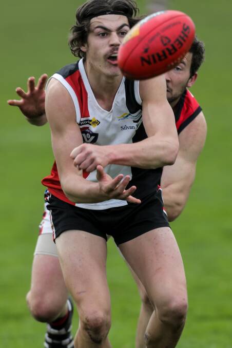 QUICK HANDS: Koroit teenager Lockie Rhook gets the ball away as pressure from a Cobden opponent closes in around him.