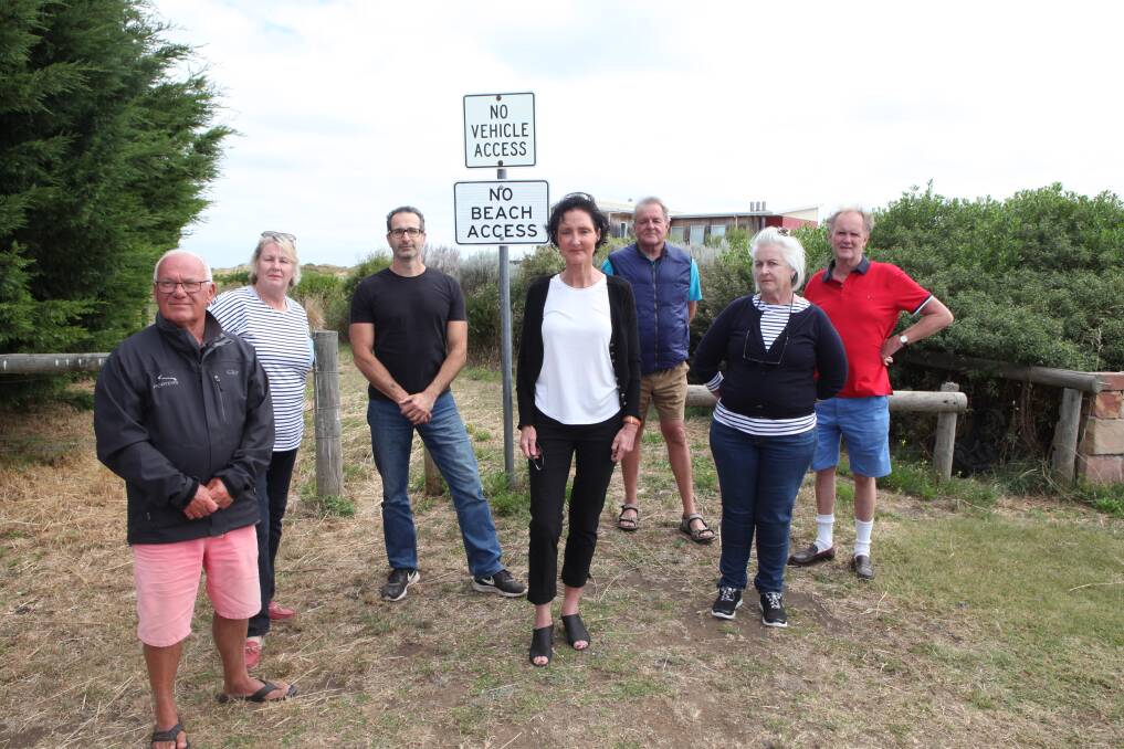 Frustration: Killarney residents John Nunn, Debbie Gooley, Marco Dabizzi, Viva-Lyn Lenehan, Will Birch, Suzi Mann and Bruce Gooley at the Towilla Way access point. The "no vehicle access" is an old sign, but the "no beach access" sign has been added in recent weeks.