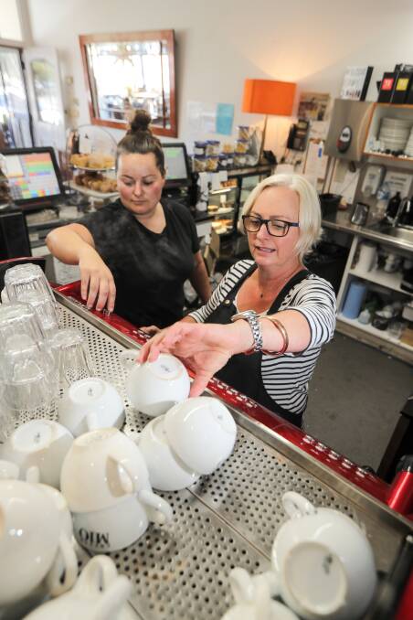 Rebecca's Cafe staff member Kellie McPherson and owner Rebecca Nelson get the coffee machine humming ahead of a busy folk festival weekend. Picture: Rob Gunstone