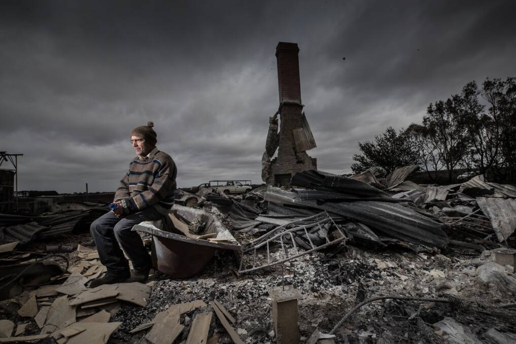 Angus McGillivery sits in the ruins of his Coyles road home near Terang after bushfire ripped through the area on Saturday night. Picture: Jason South
