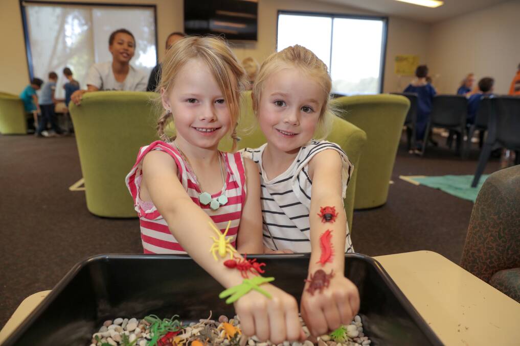 ON THE GO: Friends Karalee Tippett, 6, and Mailee Irvine, 6, get comfortable with some of the creepy crawlies. Picture: Rob Gunstone