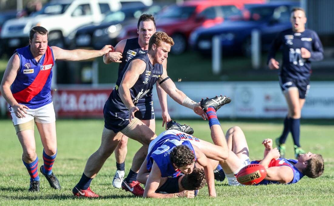 Warrnambool and Terang Mortlake players make a grab for the ball. Picture: Christine Ansorge