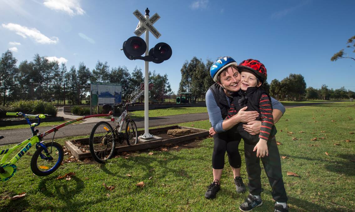 HISTORY: Kim and Christopher Leddin at the new signal lights on the rail trail in Koroit. The lights have become a popular addition to the railway station precinct. Picture: Christine Ansorge