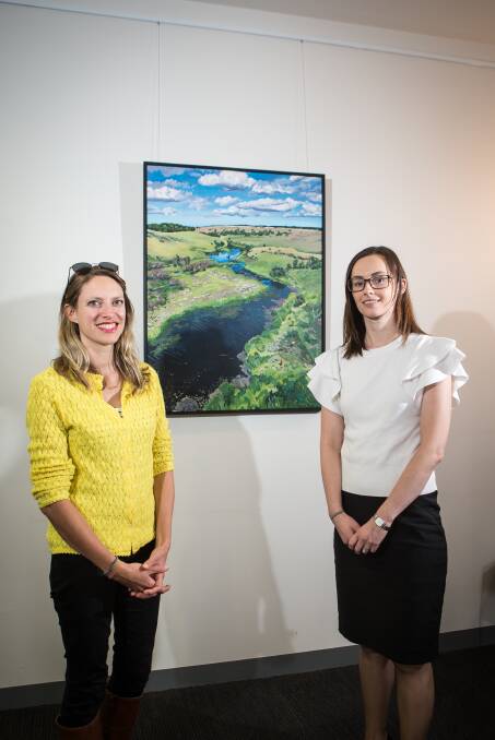 Local artist Caroline Healey and Maddens Lawyers partner Kathryn Emeny in front of some art work created by Ms Healey. Picture: Christine Ansorge