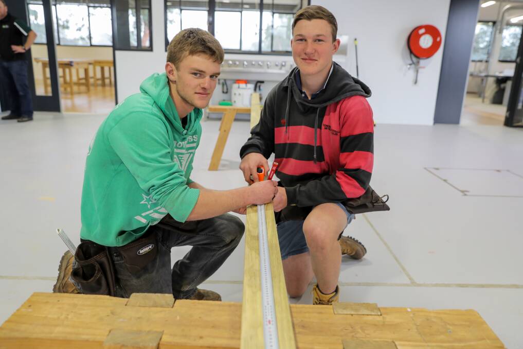 Building and construction students Grant Watson, 17, and Tom Marshall, 17, measure and cut some decking boards for a cubby house. Picture: Rob Gunstone