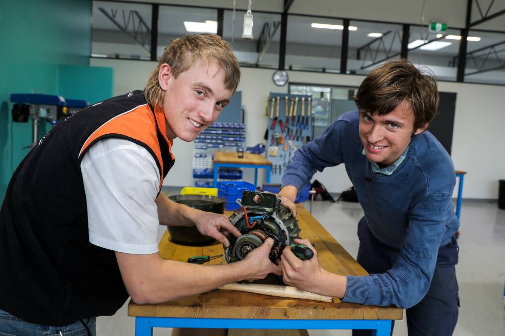Electrical trade students Leigh Ball, 17, and Daniel Nelson, 15, have a close look at a electric motor. Picture: Rob Gunstone
