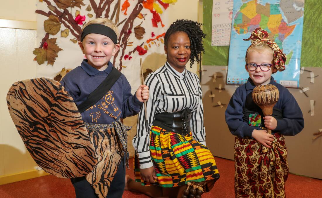 ALL SMILES:  King's College Early Years students Peter Fry, 5, and Grace Coughlan, 5, enjoy their immersive African Experience with Teremayi Manozho. Picture: Rob Gunstone