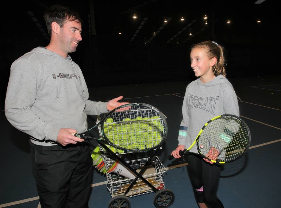 HANDY HINTS: Warrnambool tennis coach Matthew Moloney teaches Grace Biggs the nuances of the game. Picture: Anthony Brady