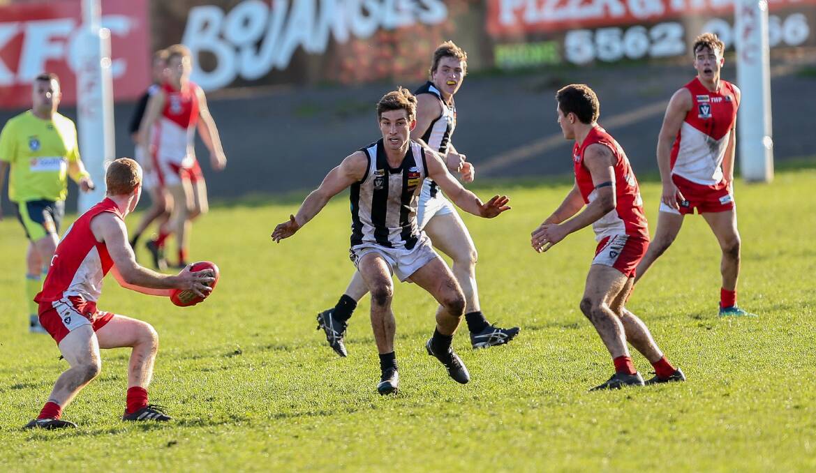 ROUND 14: Camperdown's Sam Cunnington stands guard between two South Warrnambool opponents. Picture: Christine Ansorge