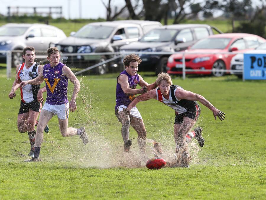 SPLASH: Port Fairy's Tyler Hetherington and Koroit's Dallas Mooney find a puddle on the Victoria Park wing. Picture: Michael Chambers