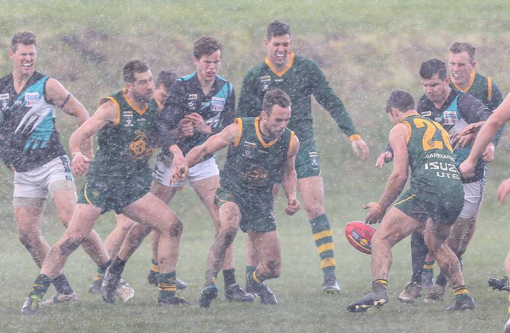 WET SLOG: The weather was a constant influence on Saturday's qualifying final between Kolora-Noorat and Old Collegians. Picture: Christine Ansorge