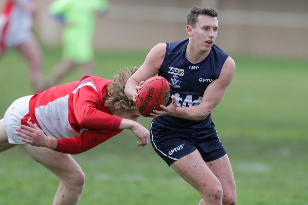 Breaking free: Mitch Bidmade of Warrnambool backs himself to evade his opponent who tries to wrap him up. Picture: Morgan Hancock .