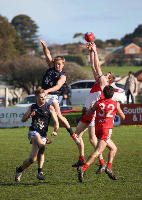REACH: South Warrnambool's Kym Eagleson gets his fingers to the ball in a marking contest against Warrnambool. Picture: Michael Chambers