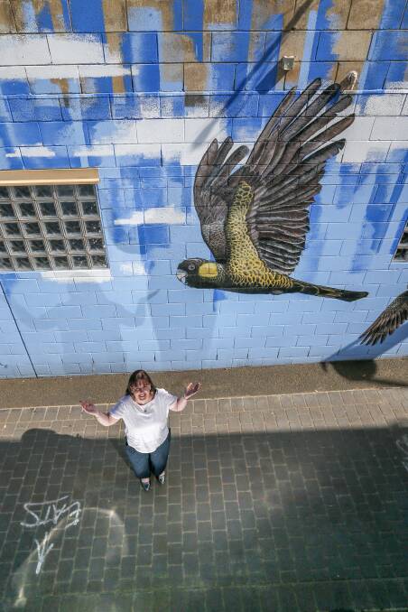 Flying high: Co ordinator economic development and business support at Warrnambool City Council Helen Sheedy examines the Jimmi Buscombe artwork In Spirit, a 32-metre feature of yellow-tailed black cockatoos against an azure sky. Picture: Michael Chambers