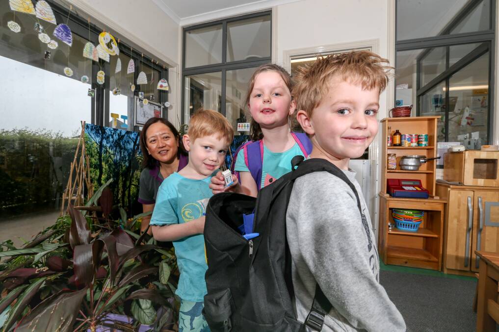 FANTASTIC: Goodstart Early Learning teacher Lisbeth Cheach watches Kaleb Pimblett and Taylah Kelly put supplies into Kaiden Mitchell's backpack. Picture: Michael Chambers