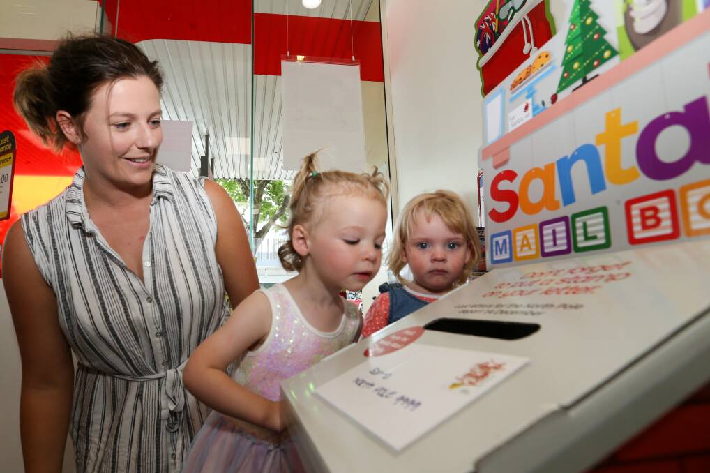 Naughty or nice: Alysha Solly watches as her daughter Matilda, 2, and friend Florence Kirkwood, 2, send off their letters to Santa. Picture: Michael Chambers