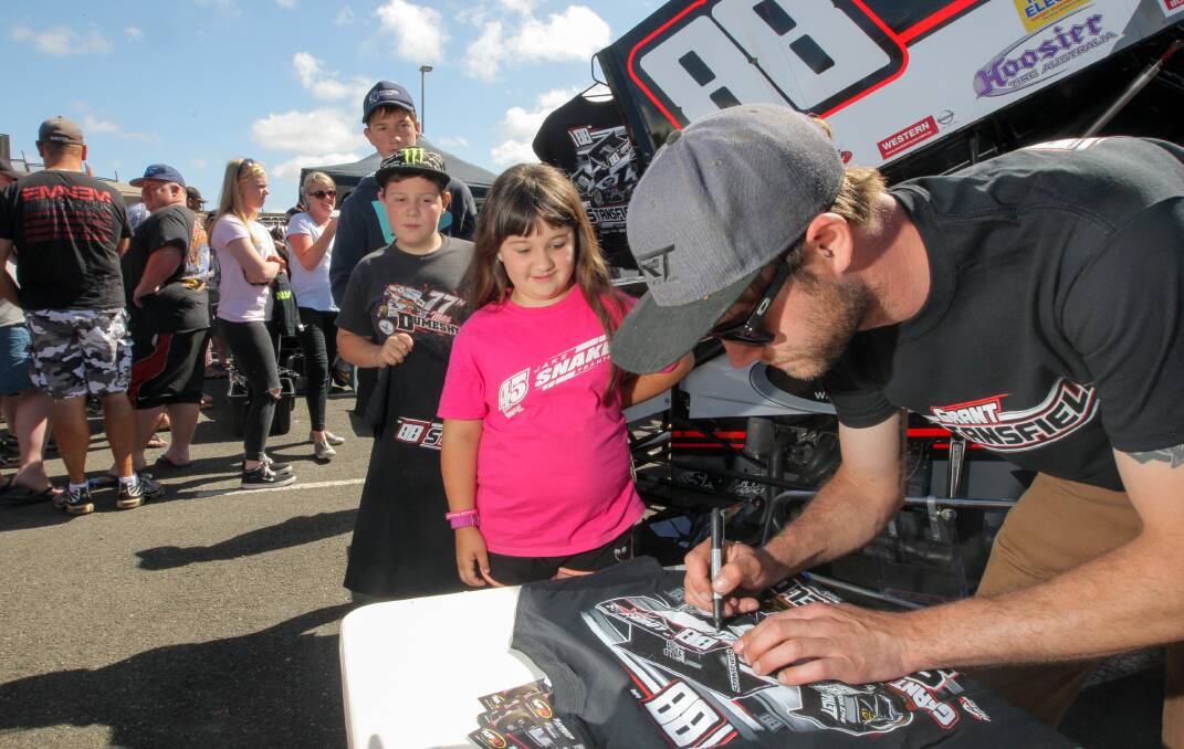 Cobden sprintcar fans Jack Gaut, 14, Thomas Gaut, 12, and Chloe Gaut, 8, line up for signatures from Warrnambool driver Grant Stansfield. Picture: Rob Gunstone