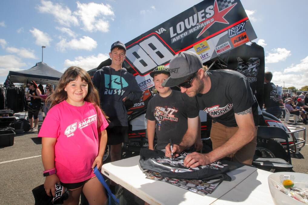 Cobden sprintcar fans Chloe Gaut, 8, Jack Gaut, 14, and Thomas Gaut, 12, line up for signatures from Warrnambool driver Grant Stansfield. Picture: Rob Gunstone