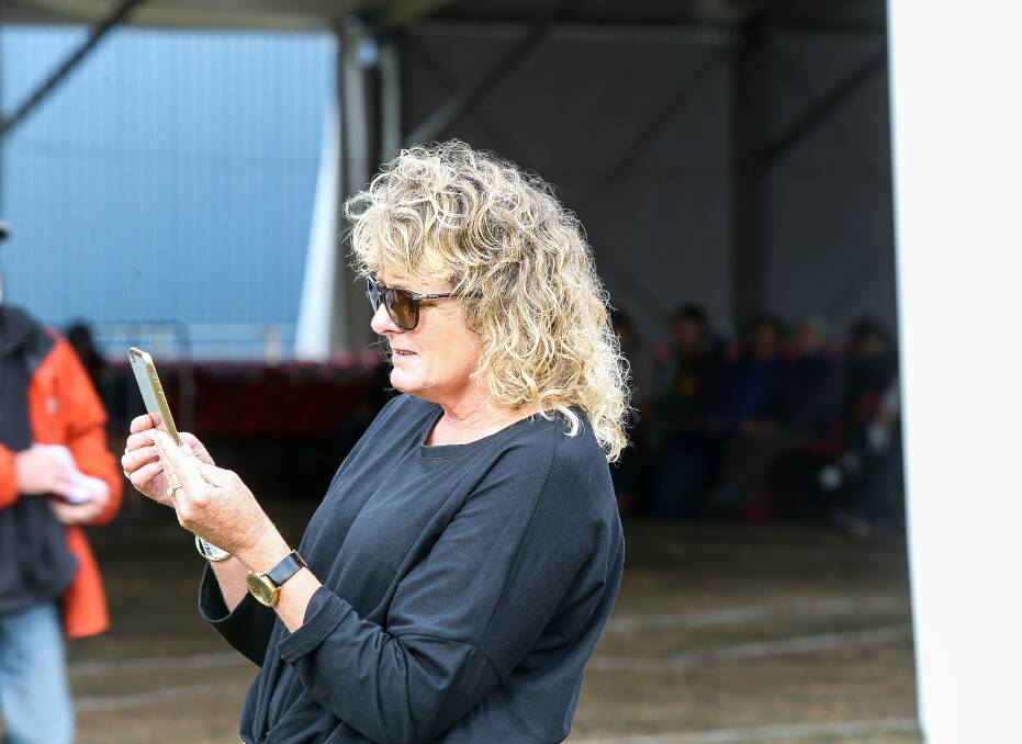 FOLKIE FUN: Warrnambool's Louise Chow, originally from Port Fairy, catches up on her phone calls during a break at the Port Fairy Folk Festival on Monday. Picture: Anthony Brady