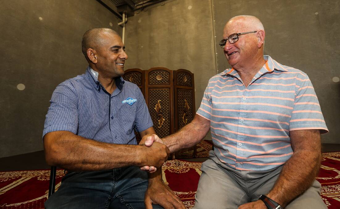 UNITED: Ghulam Khanyari shakes hands with Denis Fitzpatrick, the man who dropped off a bunch of flowers to the city's Musalla on Saturday in the wake of the Christchurch massacre. Picture: Anthony Brady.