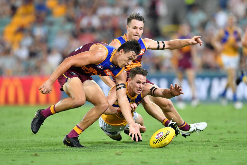 LION PRIDE: Brisbane's Hugh McCluggage and Lincoln McCarthy try and win possession from West Coast's Jack Reddan. Picture: AAP Image/Darren England