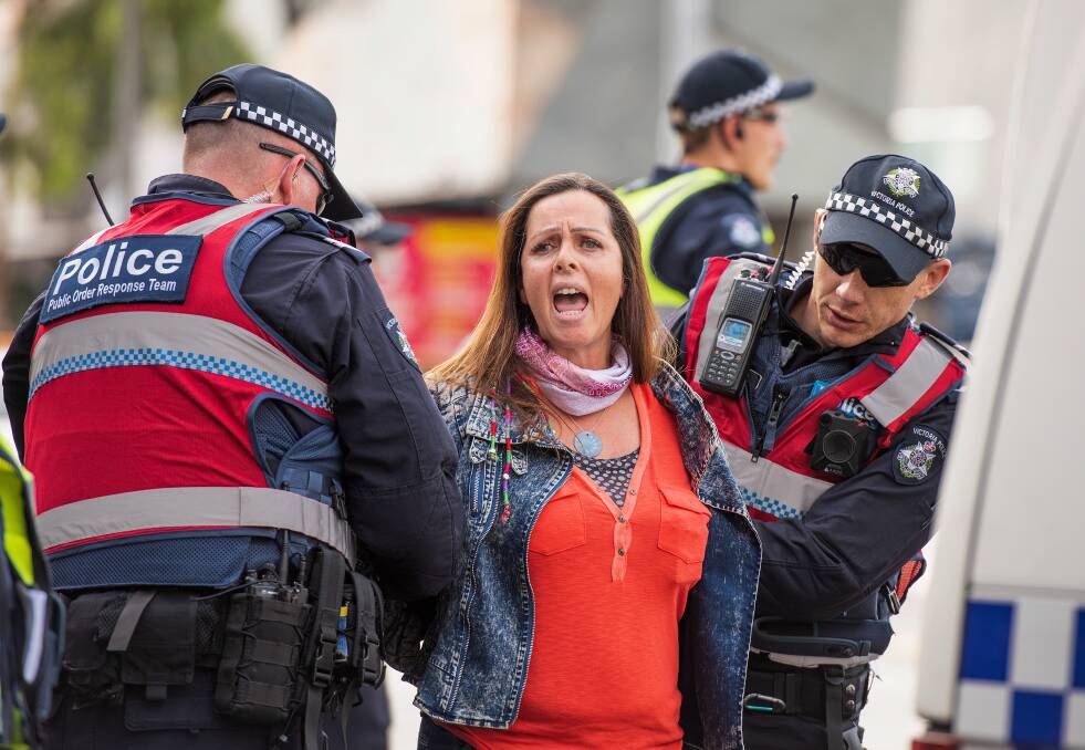 An animal rights protester who had blocked the intersections of Flinders and Swanston Street is removed by police. Photo: AAP Image/Ellen Smith