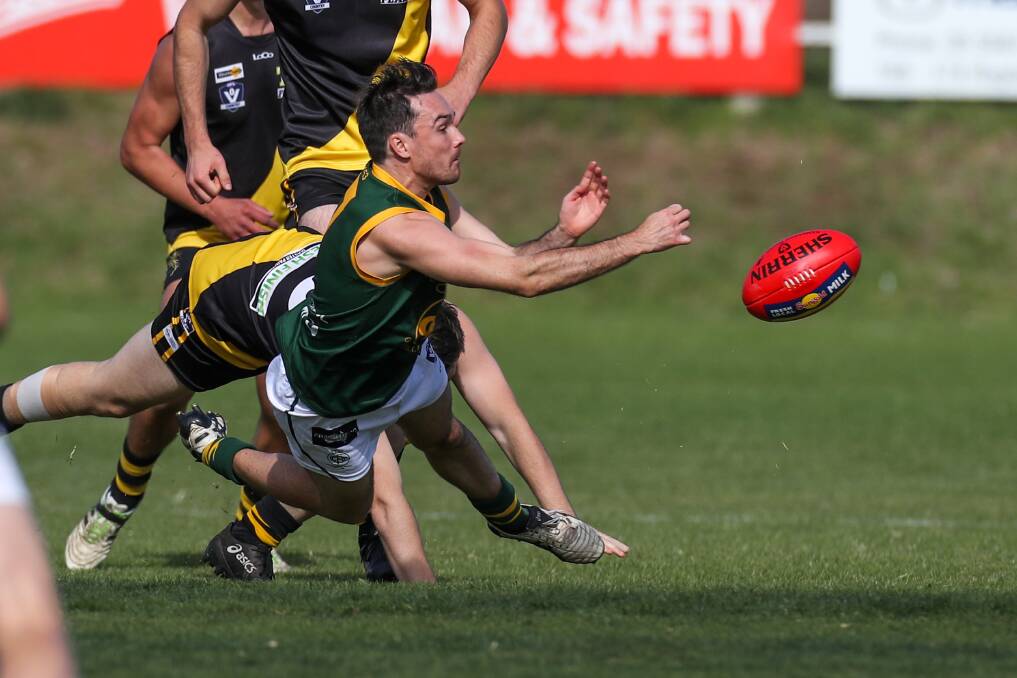Dishing it off: Old Collegians wingman Sam Thomas fires a handball out of trouble against Merrivale. The Warriors won the Good Friday encounter. Picture: Rob Gunstone