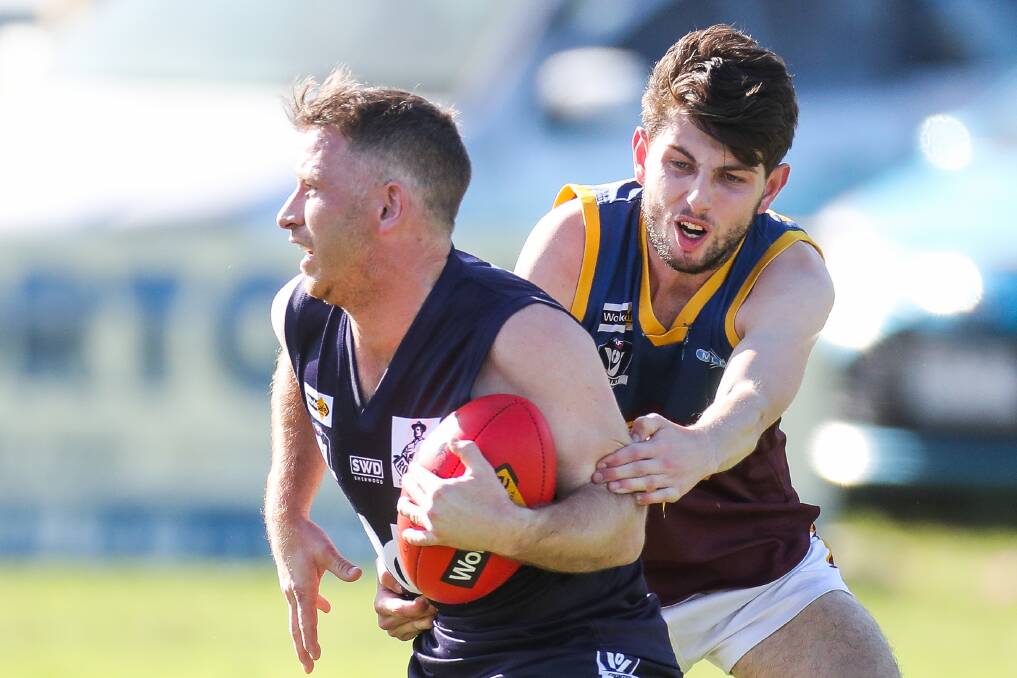 Power forward: Nirranda's Aaron Searle attempts to shrug a tackle. He kicked eight goals for the Blues on Saturday. Picture: Morgan Hancock