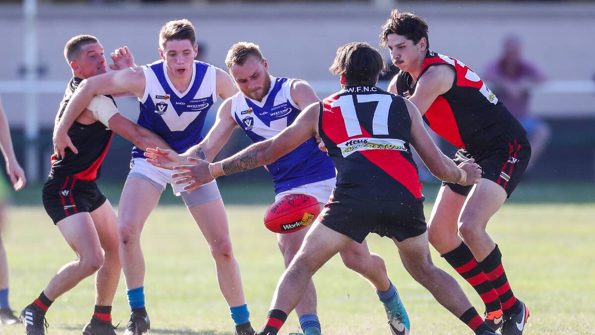 Russells Creek's Andrew McMeel kicks out of a congested centre bounce. Picture: Morgan Hancock