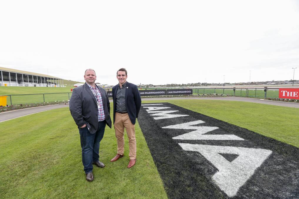 Promotion: Warrnambool City Council's manager visitor economy David McMahon and Warrnambool Racing Club chief executive Peter Downs stand beside the giant I Am Warrnambool slogan in the racecourse mounting yard. Picture: Christine Ansorge