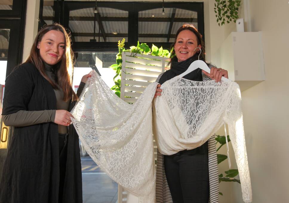 LACE LUX: Ivory Bride owner Kayla Retallack and Warrnambool Bridal Expo organiser Jess Griffey with one of the gowns that will be on display. Picture: Rob Gunstone