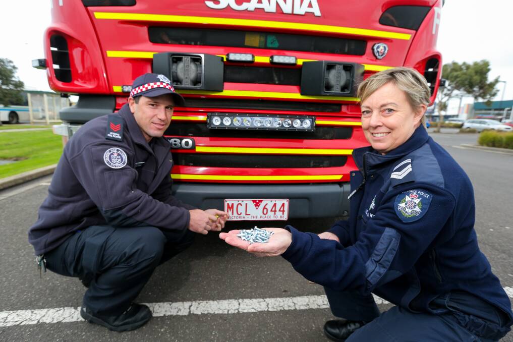Tightend Up: Warrnambool CFA Leading Firefighter Adrian Stingel and Leading Senior Constable Trudy Moreland check the number plate screws on one of the CFA vehicles. Picture: Rob Gunstone