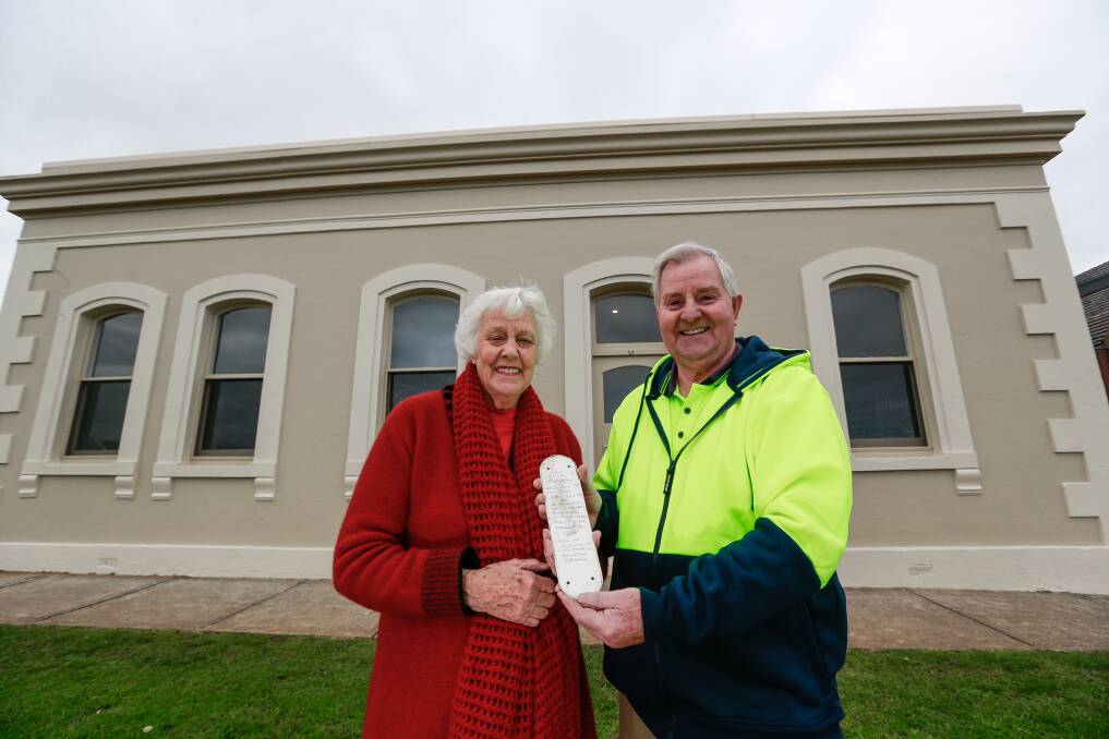 Surprise find: History buff Elizabeth O'Callaghan and builder Ray Hollingsworth with a door plate with a hidden message from historian Les O'Callaghan which was found during renovations on a historical Warrnambool house. Picture: Anthony Brady.