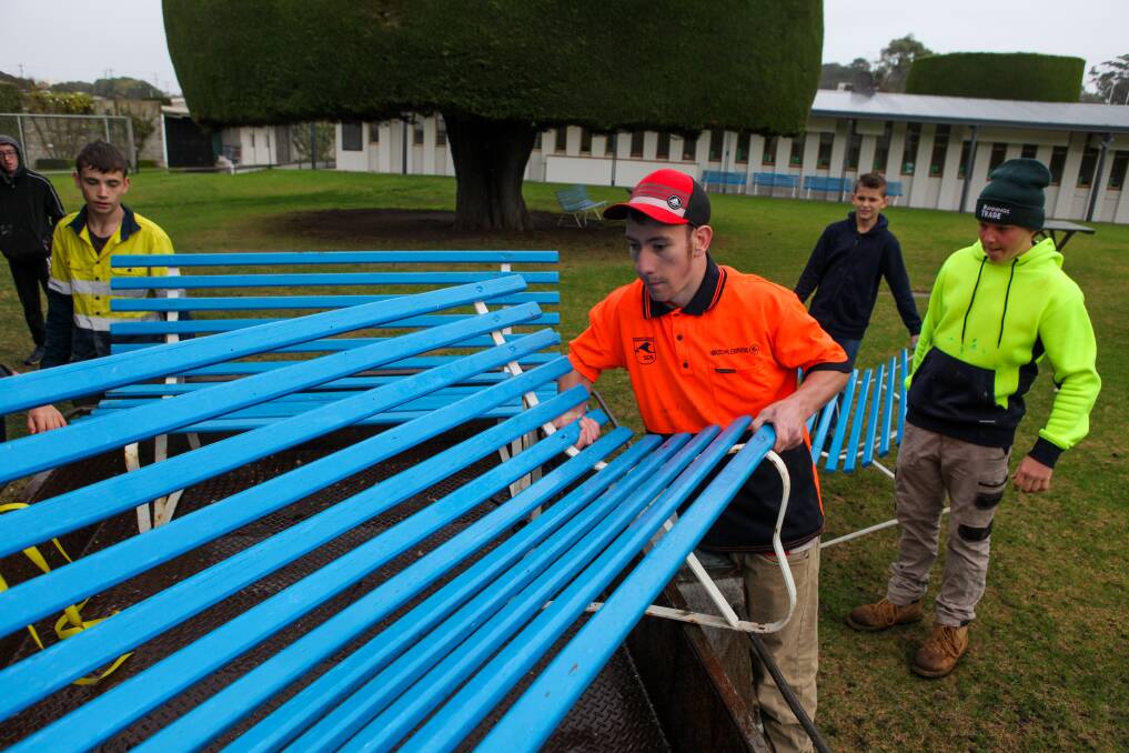 INTO THE TRAILER: Warrnambool SDS Hands on Learning students help to load up more benches to be refurbished from the racecourse. 